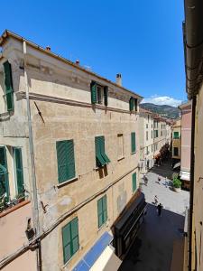 a view of an alley from a building with green shutters at Casa Aicardi in Alassio