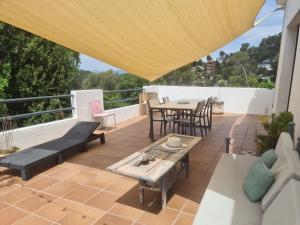 un patio con mesa y sillas en la azotea en Nature Oasis near Barcelona with swimming pool, en Sant Cugat del Vallès