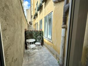 an alley with a table and chairs on a balcony at Calle de le Pazienze Apartments in Venice