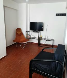 sala de estar con TV y silla en Blue Wind en Comodoro Rivadavia