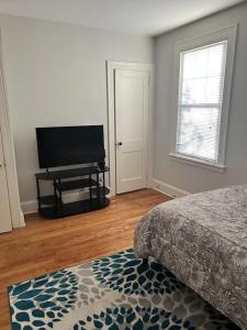Schlafzimmer mit einem Bett und einem Flachbild-TV in der Unterkunft Secret Oasis In The Heart Of Hartford in Hartford