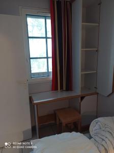 1 dormitorio con escritorio y ventana en Chez Alex & Max - Appartement duplex entre forêt et océan, en Moliets-et-Maa