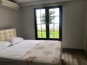 a bedroom with a bed and a large window at Seyran Seaside Apartments- 2-garden floor in Trabzon