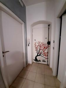 un corridoio con una porta con un albero dipinto sopra di La Nchioscia a La Spezia