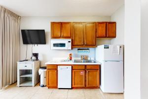 a kitchen with wooden cabinets and a white refrigerator at Destin West Gulfside Villa V402 in Fort Walton Beach