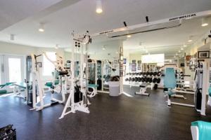 un gimnasio con varias cintas de correr y máquinas en una habitación en Destin West Gulfside Villa V402 en Fort Walton Beach