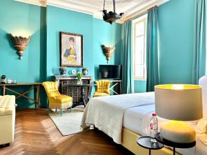 - une chambre avec des murs bleus, un lit et des chaises dans l'établissement Le Gabriel, à Claviers