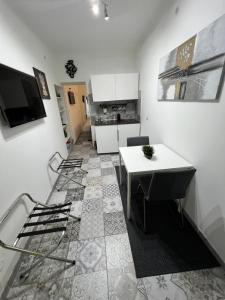 a kitchen with a white counter and a table at Gargallo Suite Ortigia in Syracuse