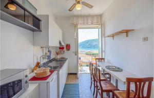 uma cozinha com mesa e cadeiras e vista para o oceano em Pet Friendly Apartment In Moneglia With Kitchen em Moneglia