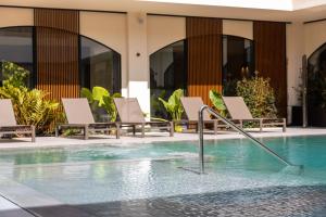 a swimming pool with lounge chairs in a hotel at Limen Wellness Hotel & Spa in Campofelice di Roccella