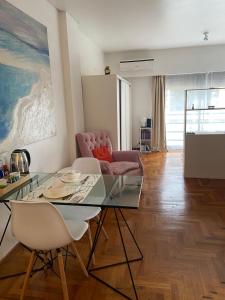 een woonkamer met een glazen tafel en stoelen bij Luxury Cañitas hermoso monoambiente in Buenos Aires
