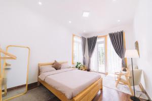 1 dormitorio con cama y ventana grande en 3 Tầng Mây (Homestay & Coffee) en Ấp Ða Lôc