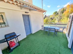 a patio with a table and chairs on a balcony at 2 pièces d’exception vue Mer in Vence