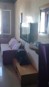 - un salon avec un canapé et une télévision dans l'établissement Studio meublé, à Riffiene