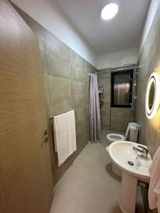 a bathroom with a sink and a toilet and a mirror at Cosy 2BR Apartment near Tirana Airport - SELF CHECK-IN 24hr in Tirana