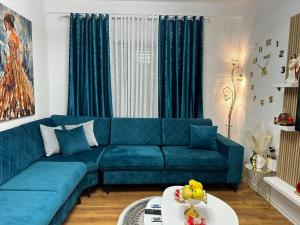 a living room with a blue couch and a table at Cosy 2BR Apartment near Tirana Airport - SELF CHECK-IN 24hr in Tirana