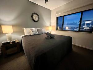 a bedroom with a large bed with a clock on the wall at Sea Renity at Waterfront - SEAVIEW in Darwin