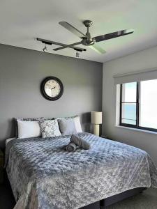 1 dormitorio con 1 cama con reloj en la pared en Sea Renity at Waterfront - SEAVIEW, en Darwin