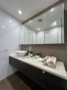 a bathroom with a counter with a sink and mirror at Sea Renity at Waterfront - SEAVIEW in Darwin