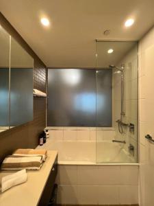 a bathroom with a shower and a sink and a tub at Sea Renity at Waterfront - SEAVIEW in Darwin