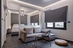 a living room with a couch and a bed at Furla Suites Athens in Athens