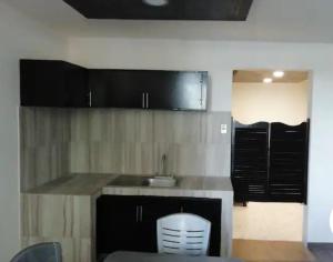 una cocina con armarios negros y fregadero en Departamento excelente zona, en Tampico