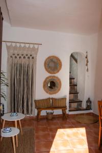 a living room with a bench and a mirror at Acogedora casa rural en Olvera ,La Morada in Olvera