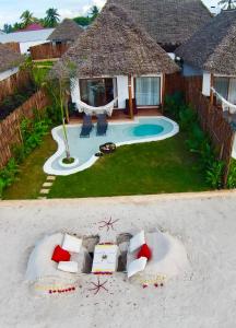 uma vista aérea de um resort com um sofá na areia em Safaya Luxury Villas - Adults only em Nungwi