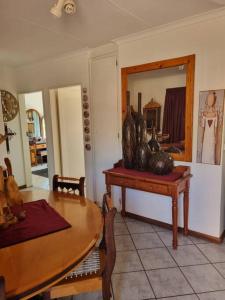 a dining room with a table and a mirror at Home away from Home in Pretoria