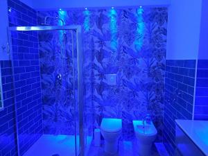 einen blauen Duschvorhang im Bad mit WC in der Unterkunft Sweet Elite House in Scafati