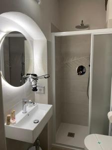 a bathroom with a sink and a shower with a mirror at Affittacamere Mirella in Gubbio
