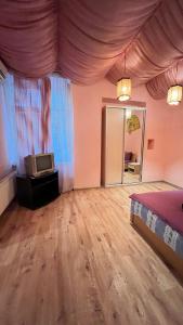 リヴィウにあるApartment Kotliarska st.-Moisha Houseのベッドルーム(ベッド1台、鏡、テレビ付)