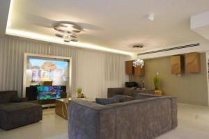 a living room with couches and a flat screen tv at סויטת החלומות in Ashkelon