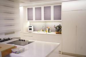 a kitchen with white cabinets and a white counter top at סויטת החלומות in Ashkelon