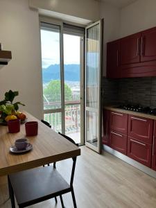 une cuisine avec des placards rouges et une table avec vue dans l'établissement Renovated Loft with Vesuvio view terrace, à Scafati