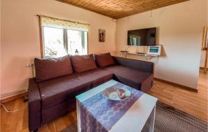 ein Wohnzimmer mit einem braunen Sofa und einem Tisch in der Unterkunft Awesome Home In Eldsberga With Kitchen in Eldsberga