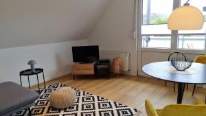 ボルクムにあるHaus Polarsternのテーブルとテレビのあるリビングルーム