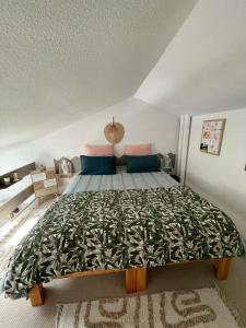 ein Schlafzimmer mit einem großen Bett mit einer grünen Tagesdecke in der Unterkunft JOLIE MAISON AU GOLF in Lacanau-Océan