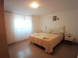 Case Vacanze San Silvestro في بودوني: غرفة نوم عليها سرير وفوط