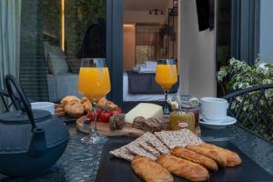 Furla Suites Athens في أثينا: طاولة مع الخبز وكأسين من عصير البرتقال