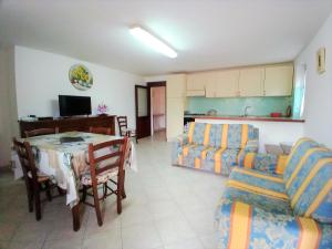 Case Vacanze San Silvestro في بودوني: غرفة معيشة مع طاولة وأريكة