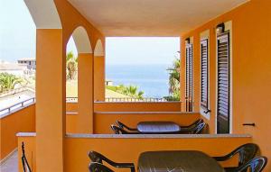 uma varanda com cadeiras e vista para o oceano em 2 Bedroom Beautiful Apartment In Valledoria em Valledoria
