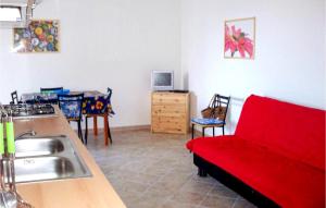uma sala de estar com um sofá vermelho numa cozinha em 2 Bedroom Beautiful Apartment In Valledoria em Valledoria