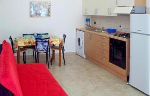 uma cozinha com mesa e cadeiras e uma cozinha com frigorífico em 2 Bedroom Beautiful Apartment In Valledoria em Valledoria