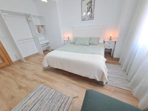 um quarto branco com uma cama e um tapete em Apartamento de 120m2 al lado de Cabarceno em Sarón