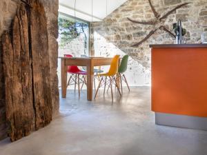 Il comprend une cuisine et une salle à manger avec une table et des chaises en bois. dans l'établissement Stone Cottage, à Elgol