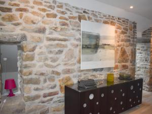 a stone wall in a room with a black dresser at Stone Cottage in Elgol