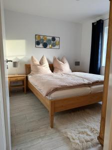 a bedroom with a bed with white sheets and pillows at Ferienwohnung Landblick in Steenfeld