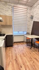 una cucina con pavimenti in legno, tavolo e finestra di 10/8 Kotliarska Moisha House a Lviv