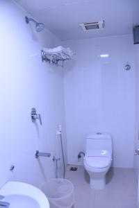 a white bathroom with a toilet and two sinks at EVEREST PARK RESIDENCY in Tiruchchirāppalli